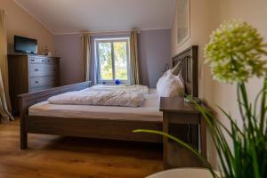 a bedroom with a bed with a window and a dresser at Landhotel Rehedyk in Sankt Michaelisdonn