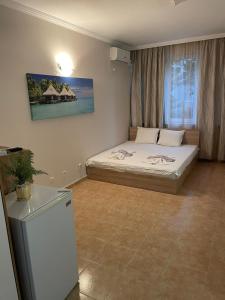 a bedroom with two beds and a refrigerator in it at Apartment See Breeze in Sunny Beach