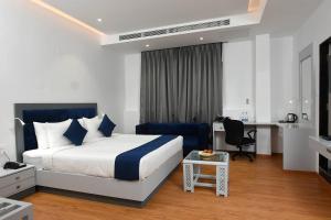 a hotel room with a bed and a desk at Kyriad Hotel Pimpri in Pune +35 photos
