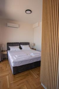 a bedroom with a large bed with white sheets at Vertmont Villa in Sveti Stefan