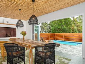 a dining room with a table and chairs and a swimming pool at Bains View Olive and Guest Farm in Wellington