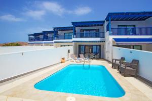 une villa avec une piscine et une maison dans l'établissement Atlantis, à Puerto Calero