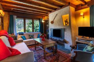 a living room with a couch and a tv at Chalet Le Margouillat in Les Houches