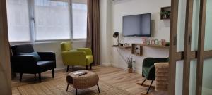 a living room with two chairs and a tv at Alexandre Herculano Oporto Residence I II & III in Porto