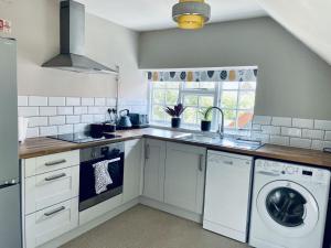 a kitchen with a sink and a washing machine at George and Dragon in Horsham