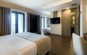 a hotel room with a bed and a television at Oca Oriental Porto Hotel in Porto