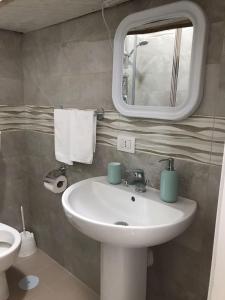 ein Bad mit einem Waschbecken und einem Spiegel in der Unterkunft GIOELE'S HOME in Scafati