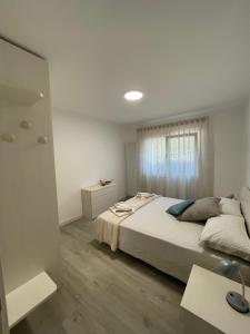 Habitación blanca con cama y ventana en Sisila Locazione, en Vittorio Veneto