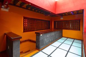 a room with orange walls and a tiled floor at Hotel Parque España in Mexico City