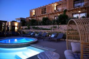 a patio with a pool and chairs and a building at Hotel Palazzu & SPA - Adult Only in Galeria