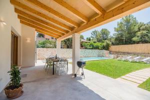 a patio with a table and chairs and a pool at Villa Mar Clara By SunVillas Mallorca in Cala de Sant Vicent