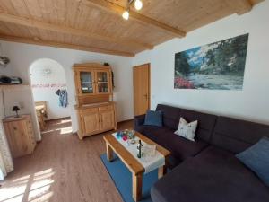 een woonkamer met een bank en een tafel bij Haus am Forstamt 11 Ferienwohnungen in Ramsau