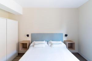a bedroom with a large white bed with two night stands at Housing León Azabachería 1A, 1B, 2A, 2B in León