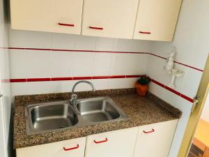 kuchnia ze zlewem oraz czerwonymi i białymi kafelkami w obiekcie Apartments in the Center of Santa Pola w mieście Santa Pola