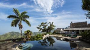 a house with a swimming pool and a palm tree at Strawberry Hill in Newcastle