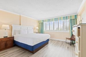 a bedroom with a large bed and a window at 2-Bedroom Carolina Dunes Condo with Private Balcony and Ocean Views in Myrtle Beach