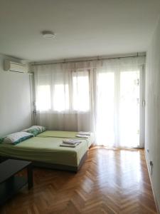 um quarto com uma cama num quarto com janelas em Pretty big double bed room with balcony em Split