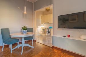 una cucina con tavolo, due sedie e una TV di Home Terrace ad Alassio Altre 5 foto