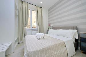 a white bedroom with a bed and a window at Gialli Vatican Guesthouse in Rome