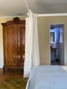 a bedroom with a bed and a wooden cabinet at REFUGIUM Theresienstraße 19 - Chambre Morisot in Rhodt unter Rietburg