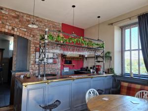 a kitchen with a counter with a table and some plants at Herdwicks in Millom