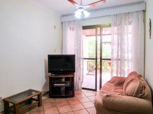 a living room with a couch and a flat screen tv at Apto a 600 metros da Praia Grande em Ubatuba SP in Ubatuba