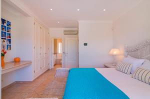 a bedroom with a large bed with a blue blanket at Oceans 8. in Almancil