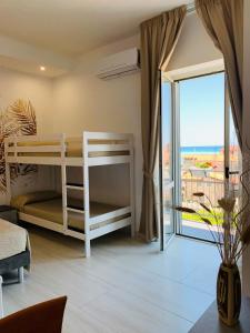 a bedroom with bunk beds and a view of the ocean at B&B Birillo in Cariati