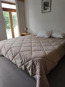 ein großes Bett in einem Schlafzimmer mit Fenster in der Unterkunft Valentim House in Viana do Castelo