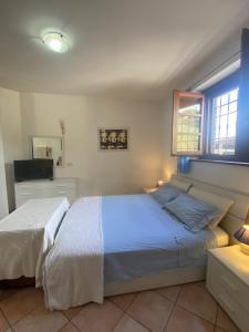 1 dormitorio con 2 camas y TV en Villa Rosa, en Gaglietole