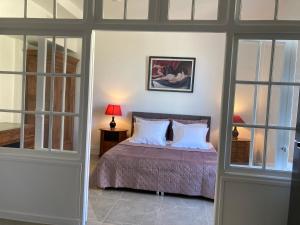 a bedroom with a bed with white pillows at Casa La Palma Le 48 in Soissons