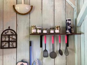 a wooden wall with a shelf with utensils on it at LE PETIT REFUGE DU VAL D’EMERAUDE in Soudorgues