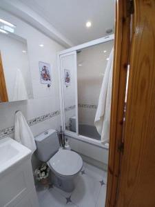La salle de bains blanche est pourvue de toilettes et d'un lavabo. dans l'établissement Bonito apartamento en Laredo, à Laredo