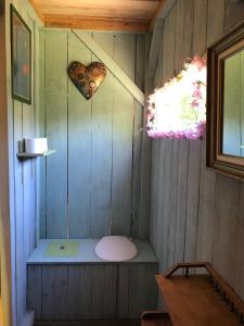 a small room with a bench in a wooden house at LE PETIT REFUGE DU VAL D’EMERAUDE in Soudorgues