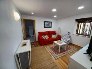 a living room with a red couch and a table at Bonito apartamento en Laredo in Laredo