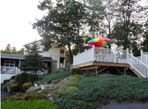 a person with a colorful umbrella on a deck at Pinebrook - Three Bedroom House in Lake George