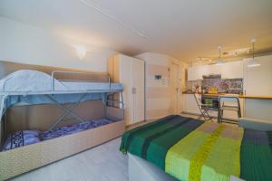Un dormitorio con dos literas y una cocina. en Monolocali Le Lecce Pool & Tennis, en Capoliveri