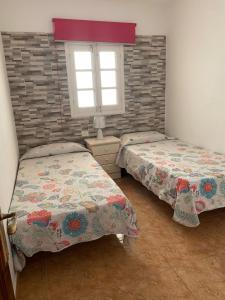 プラヤ・デル・クーラにあるDemelza Beachのベッドルーム1室(ベッド2台、窓付)