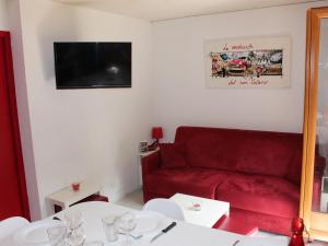 a living room with a red couch and a table at Studio Valloire, 1 pièce, 4 personnes - FR-1-263-3 in Valloire