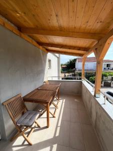 a wooden table and two chairs on a balcony at Apartmani Mia in Drage