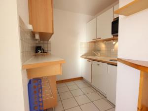 a small kitchen with white cabinets and white tiles at Charmant 3 pièces, terrasse Sud, prox. pistes, 7 pers., animaux admis - Vallandry - FR-1-411-166 in Landry