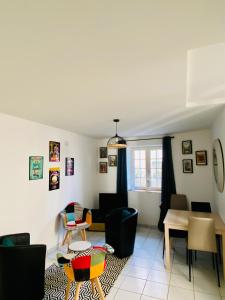 a living room with a table and chairs at Hotel Abat Jour in Nantes