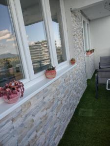 einen Balkon mit Fenstern und Pflanzen in der Unterkunft Kilátó Apartman in Tapolca