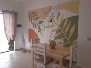 una sala da pranzo con tavolo e murale di piante di A.M.A Appartament a Calheta Do Maio