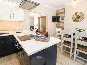 a kitchen with a counter with a sink and a table at Lobster Pot Retreat in Newbiggin-by-the-Sea