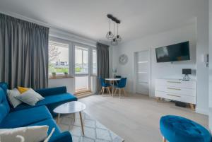 Dom & House - Apartments Mauritius في سوبوت: غرفة معيشة مع أريكة زرقاء وطاولة