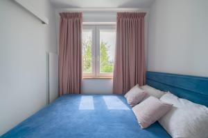 Dom & House - Apartments Mauritius في سوبوت: غرفة نوم بسرير ازرق ونافذة