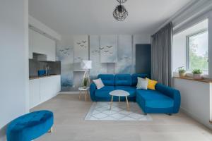 索波特的住宿－Dom & House - Apartments Mauritius，客厅配有蓝色的沙发和桌子