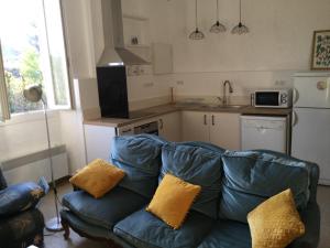 a living room with a couch and a kitchen at Chez Bacchus in Gras