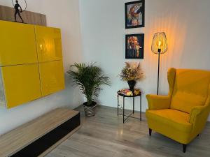 コンスタンツァにあるApartament Boema Constantaのリビングルーム(黄色い椅子、テーブル付)